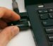 A Close Up Of A Hand Inserting A Usb Drive Into A Laptop Port, Highlighting Technology And Connectivity.